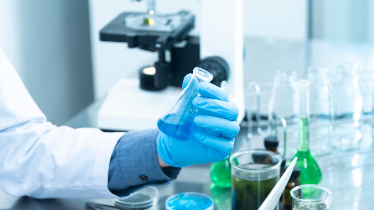 Laboratory vial and microscope representing protein science and enzyme research